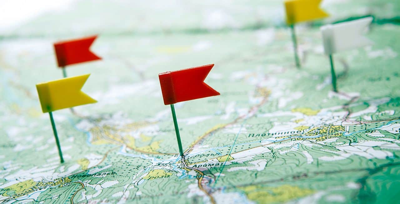 topographic map with flag pushpins close up; Analytics and Career Mapping concept