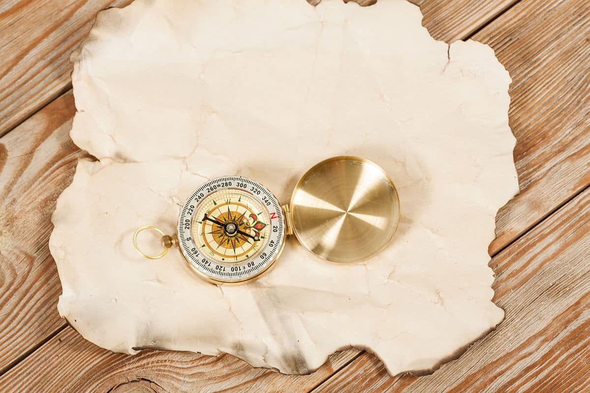 Old map with compass on old wooden background.