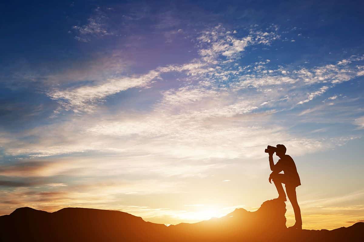 Man looking through binoculars at sunset; Talent Management Employee Expectations concept