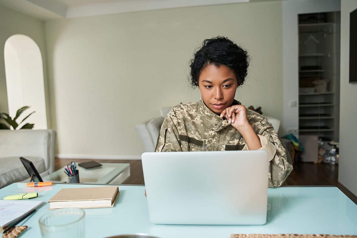 portrait view of soldier looking at laptop screen; DOD, AI, military reserves concept