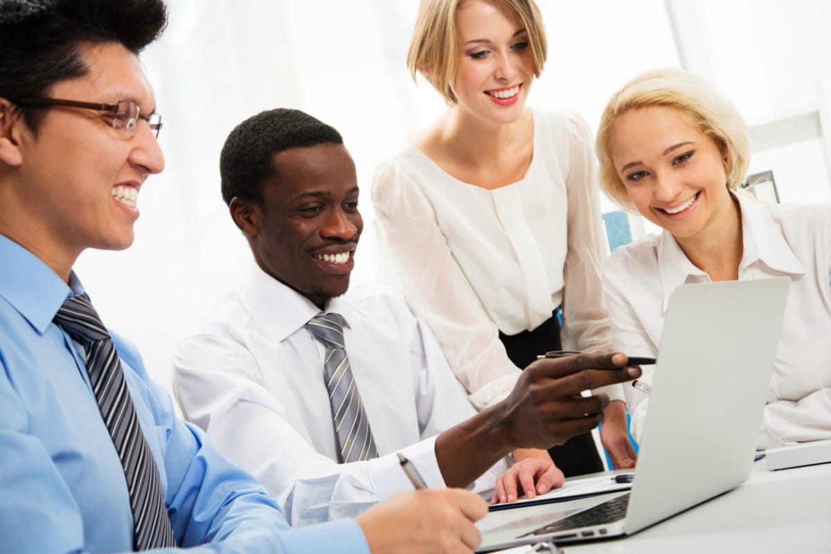 team working at a laptop representing unconscious bias in a company culture