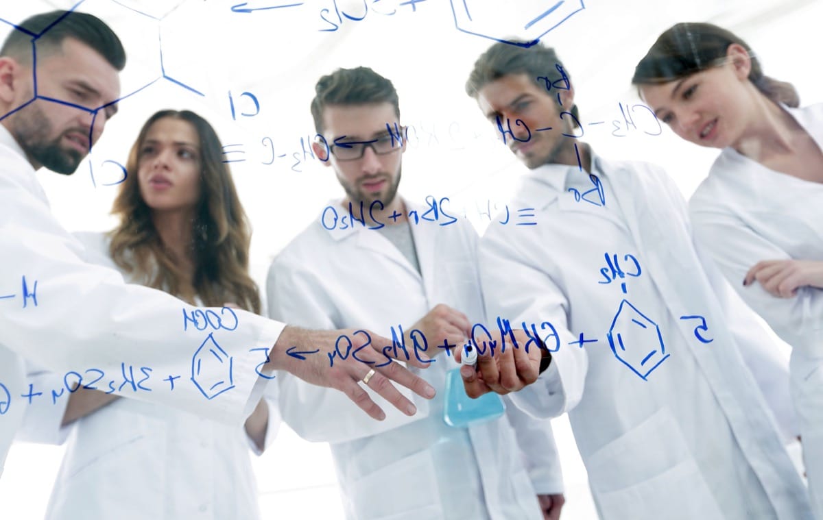 view through the transparent Board. a group of scientists analyze information.concept of Clinical trials