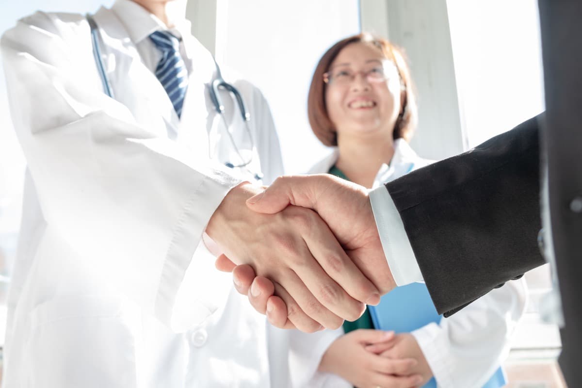 Doctor and business people shaking hands