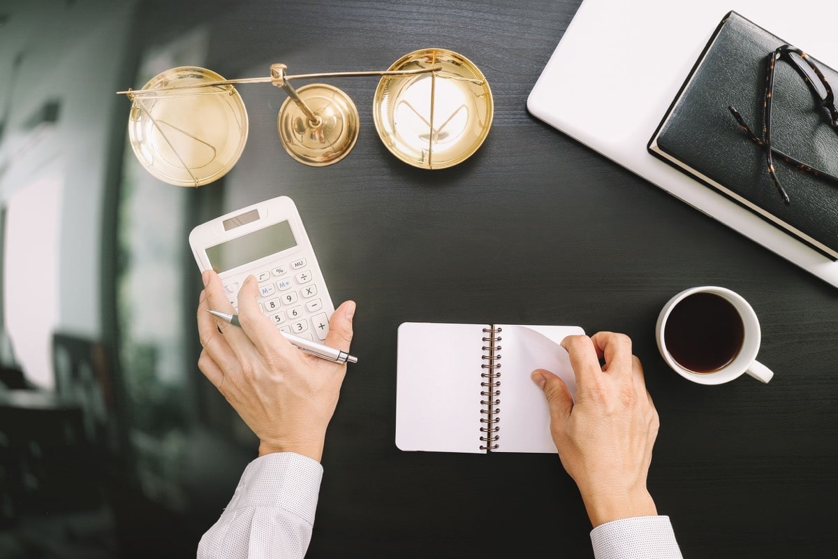 businessman working on accounts using a calculator and laptop computer and documents in modern office; recruiting tech talent concept