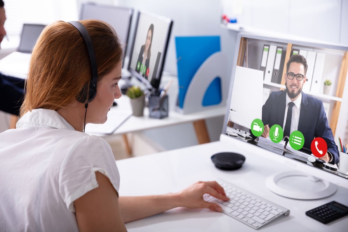 Close-up Of Businesswoman Video Conferencing With Her Male Colleague On Computer At Workplace; adapt your hiring concept