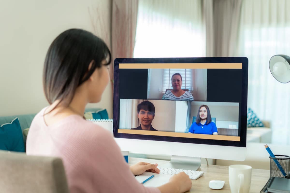 Back view of business woman talking to her colleagues about plan in video conference; Manage Remote Workers concept