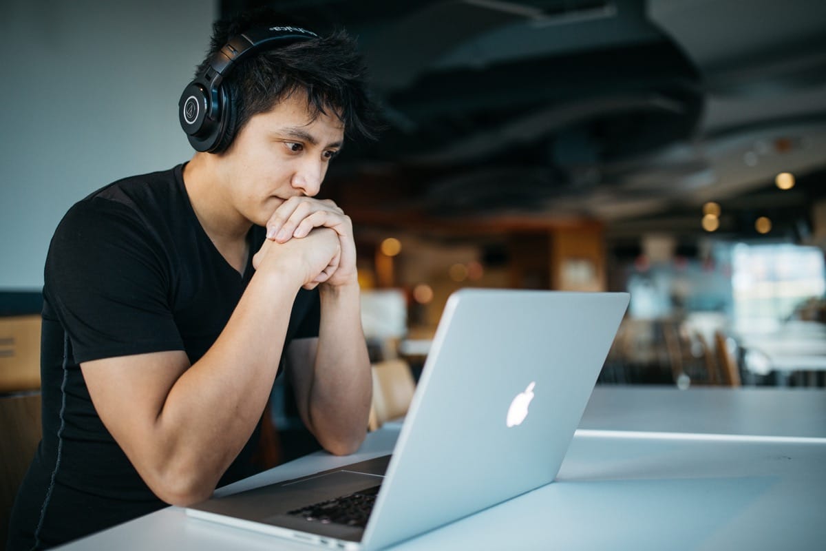 young coder working at a coffeeshop; pandemic impact, software developer jobs concept