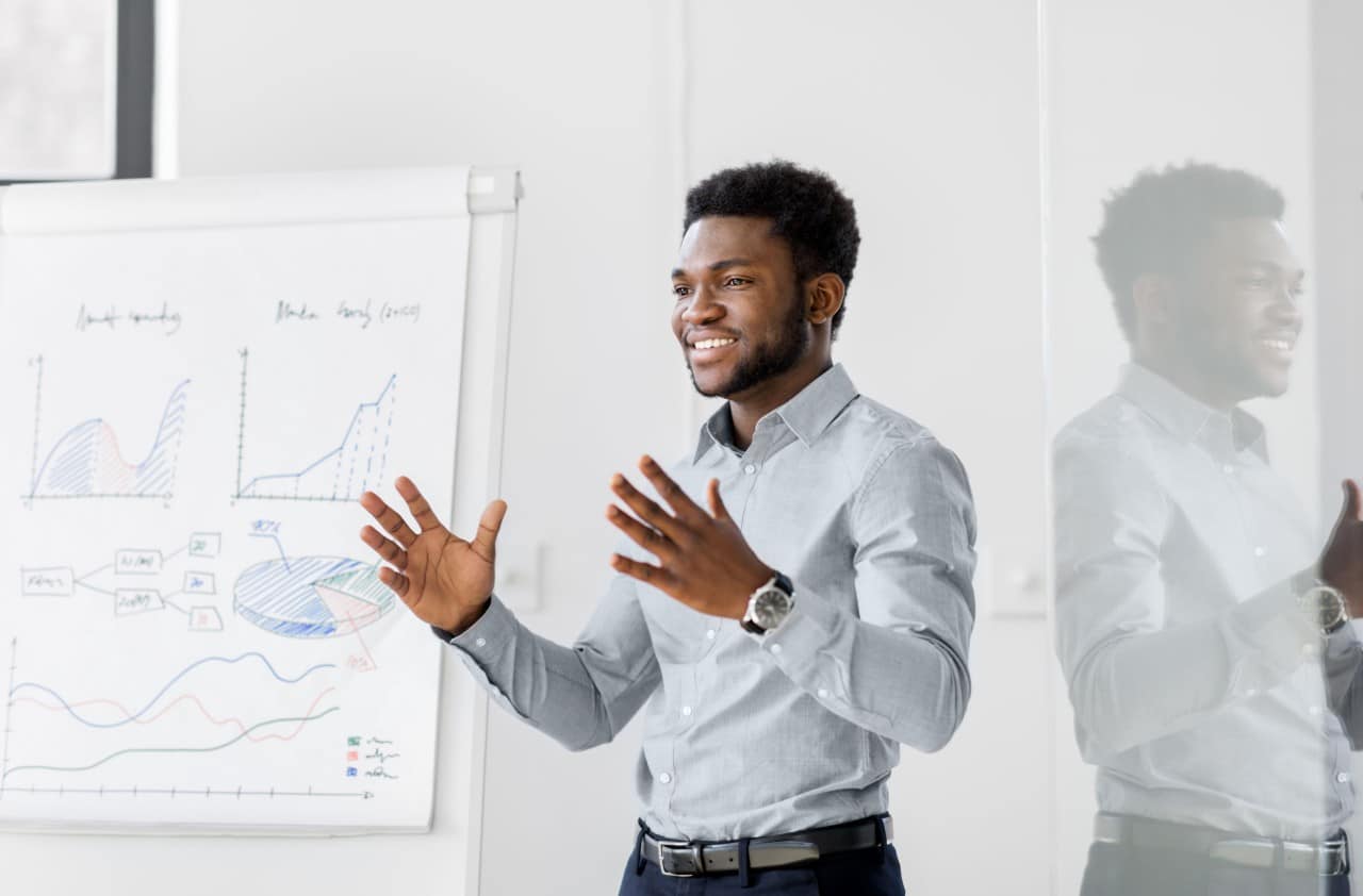 hip businessman gives presentation in front of colorful whiteboard; creative economy talent management concept