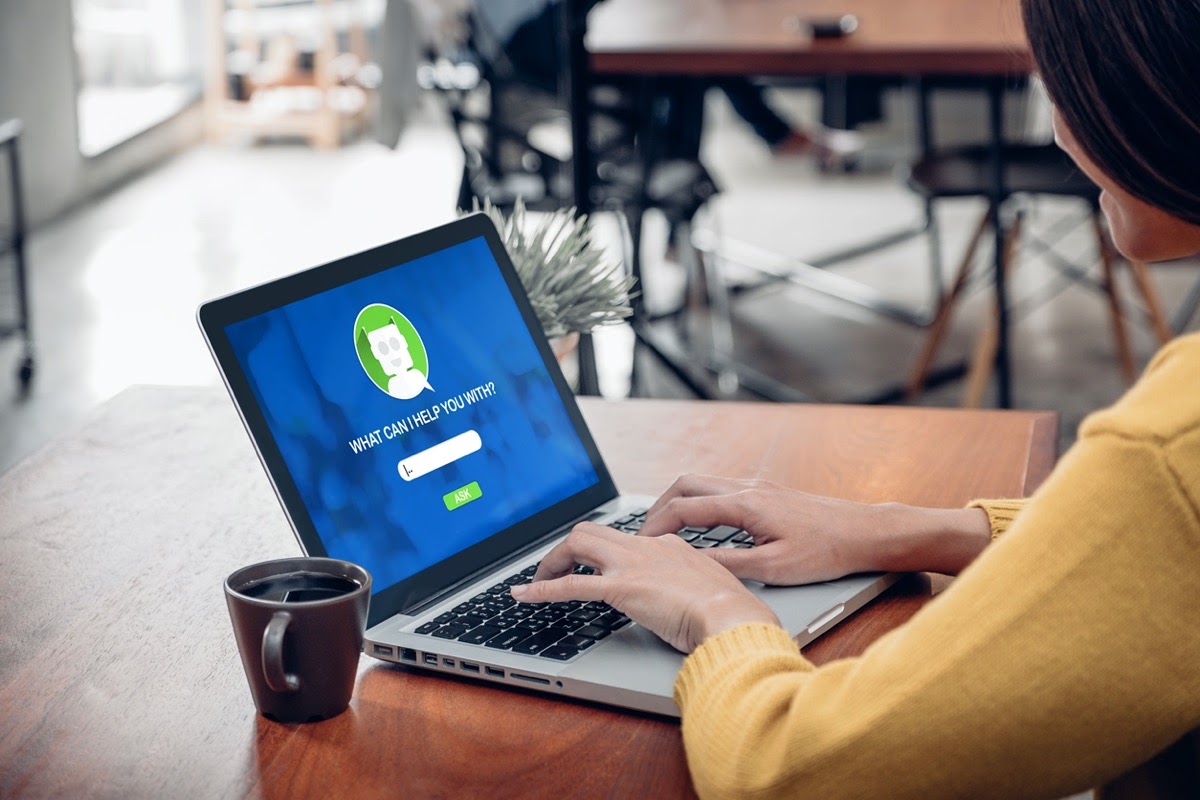 woman using chat bot function in app on laptop screen; ai and employer brand concept