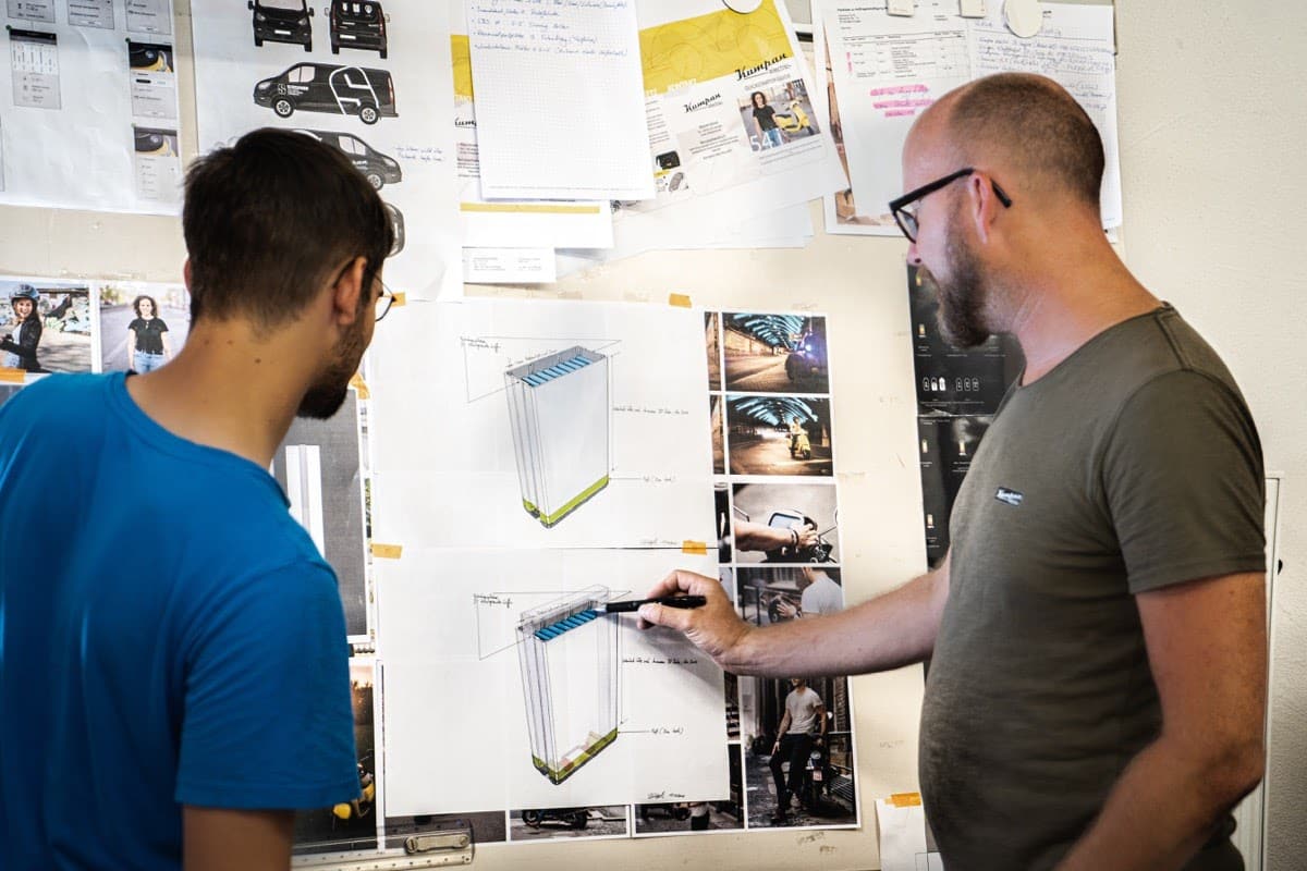 two engineers examine a diagram on a whiteboard; post-pandemic remote work concept