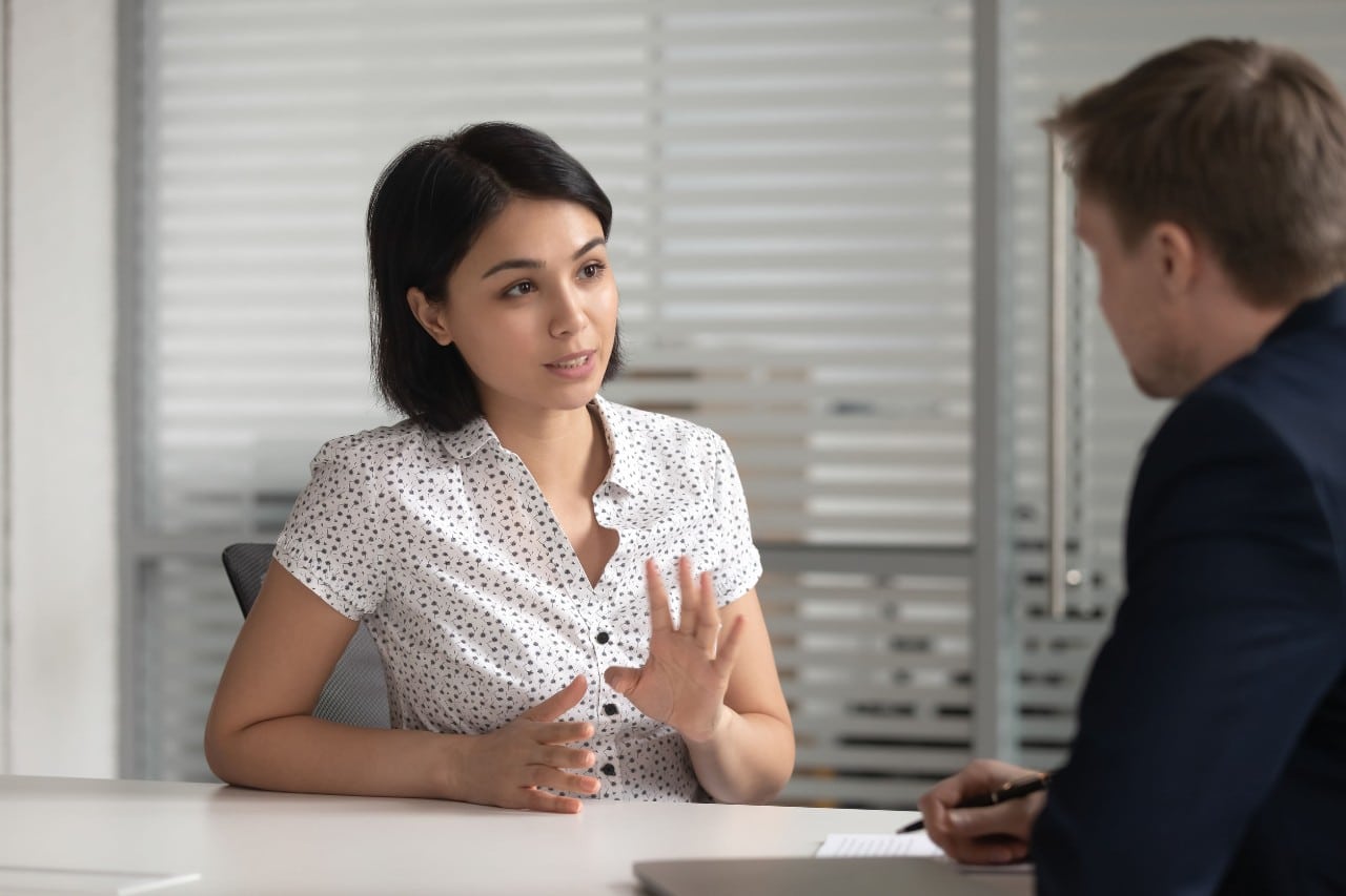 woman at job interview being questioned by a man in a suit; workforce planning concept