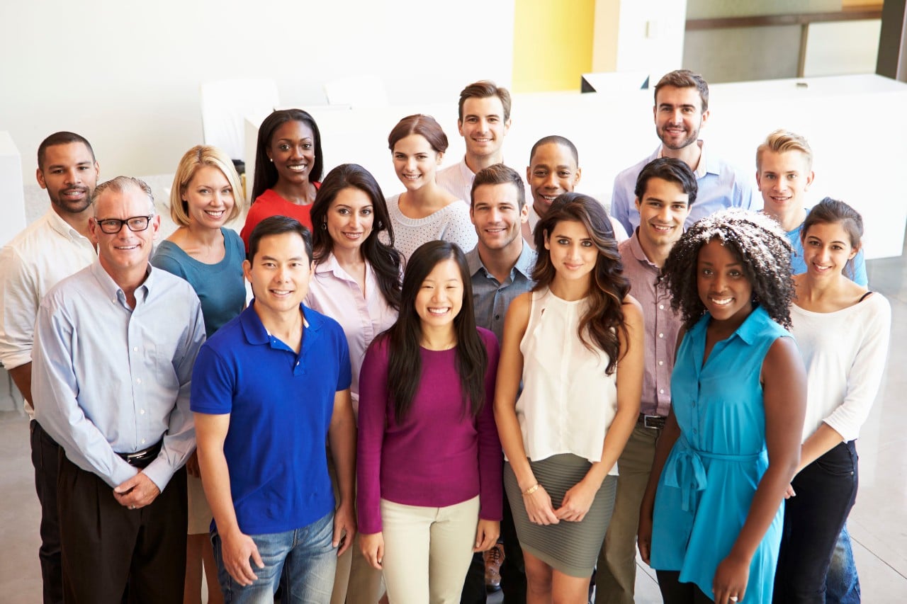 large group of office workers smiling for a portrait; internal talent shifts concept