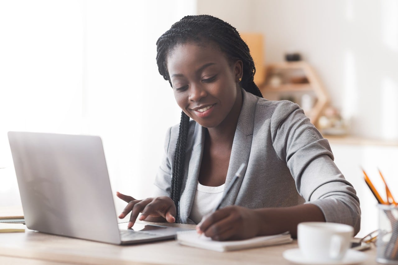professional on laptop at kitchen table; hiring across time zones concept