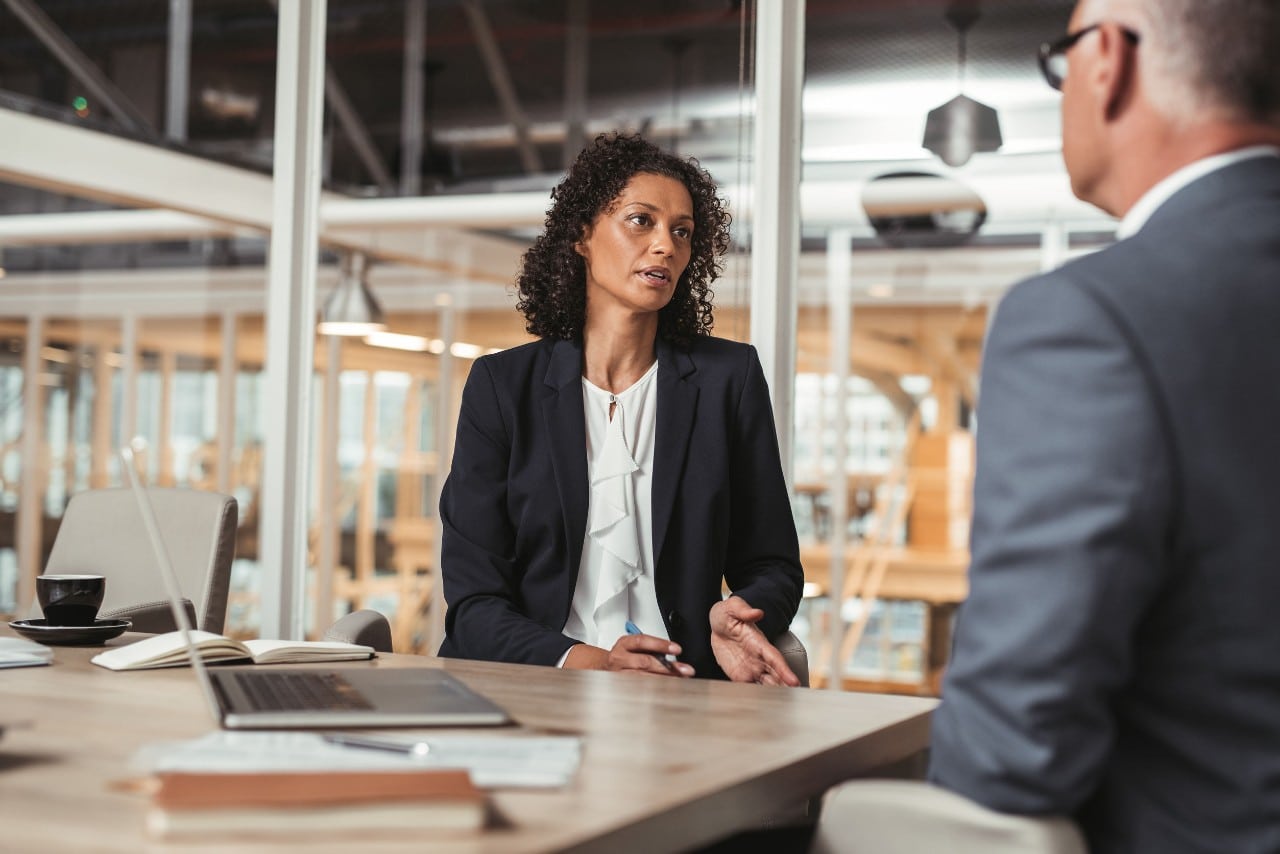 two workers in a warehouse look at laptops; hr transformation concept