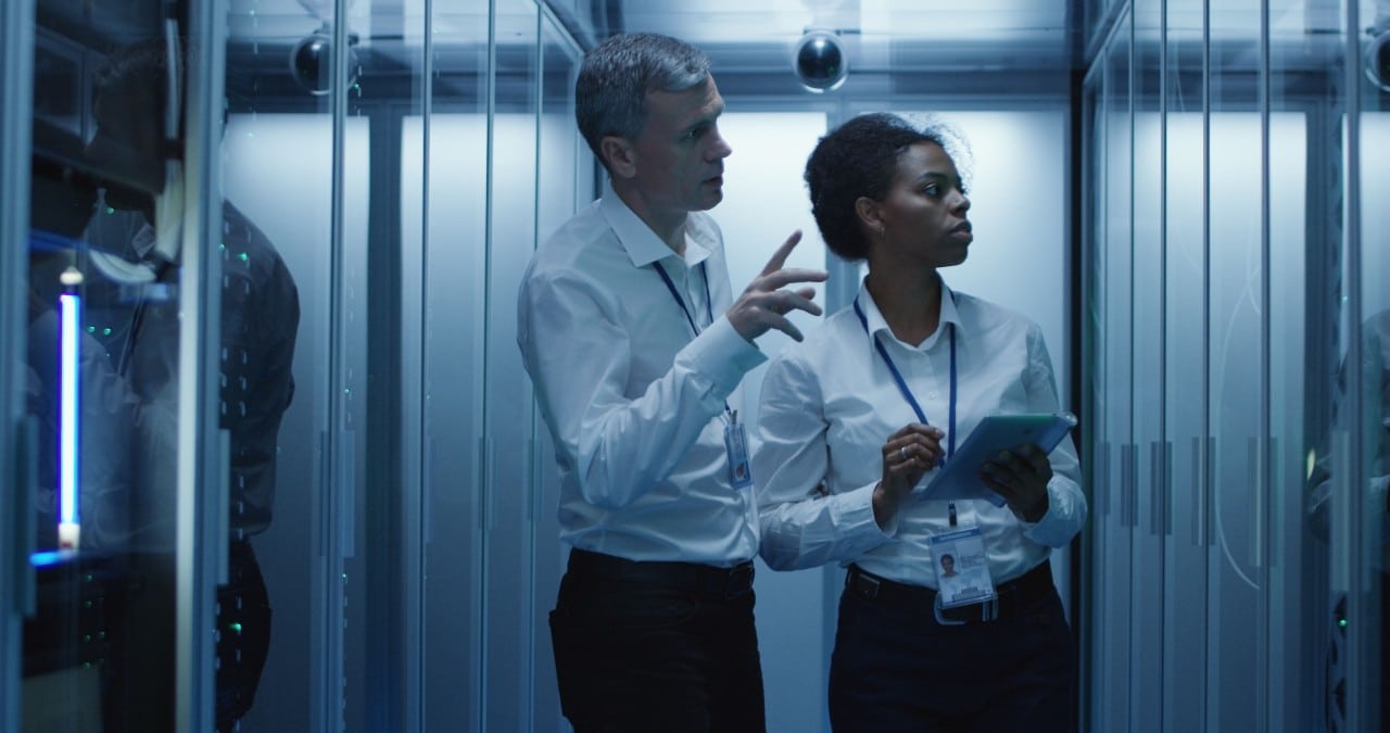 two IT workers in a server room; cross-training and upskilling employees concept