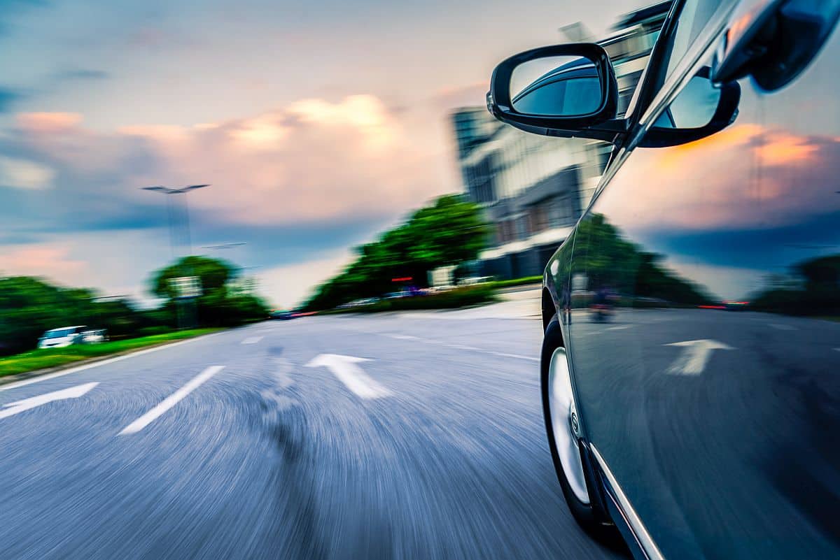 Side view of black car driving on the country road; traditional recruiting misses talent concept