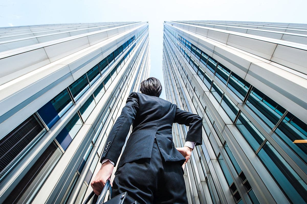 Businessman looking up at the high building, low angle