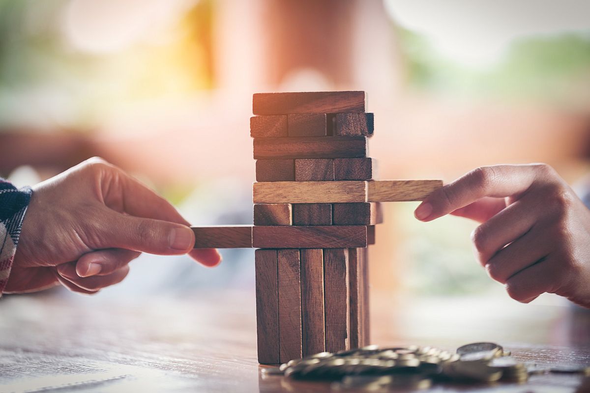 two people playing Jenga, a game of physical skill using wooden blocks; adaptive workforce concept