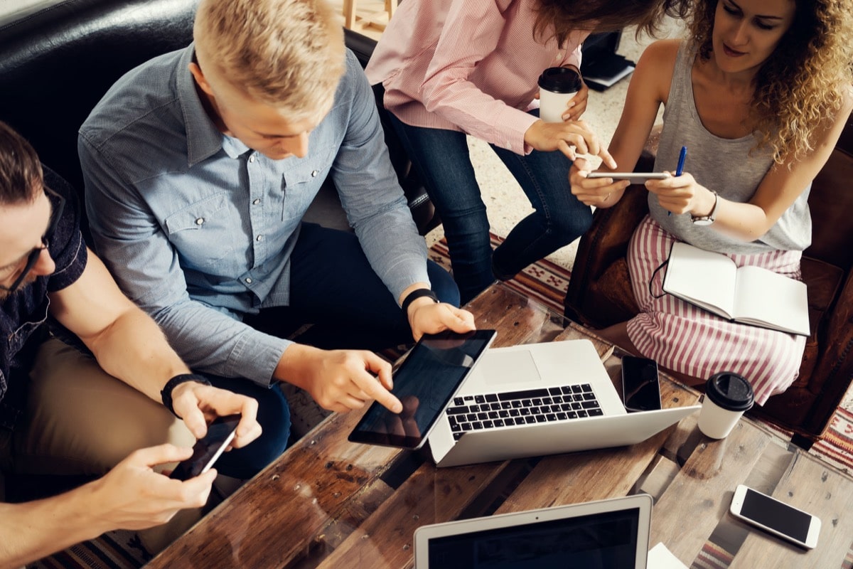 Group Young Coworkers Making Great Business Decisions.Creative Team Discussion Corporate Work Concept Modern Studio Loft.New Startup Marketing Idea Presentation.People Touching Screen Digital Gadgets