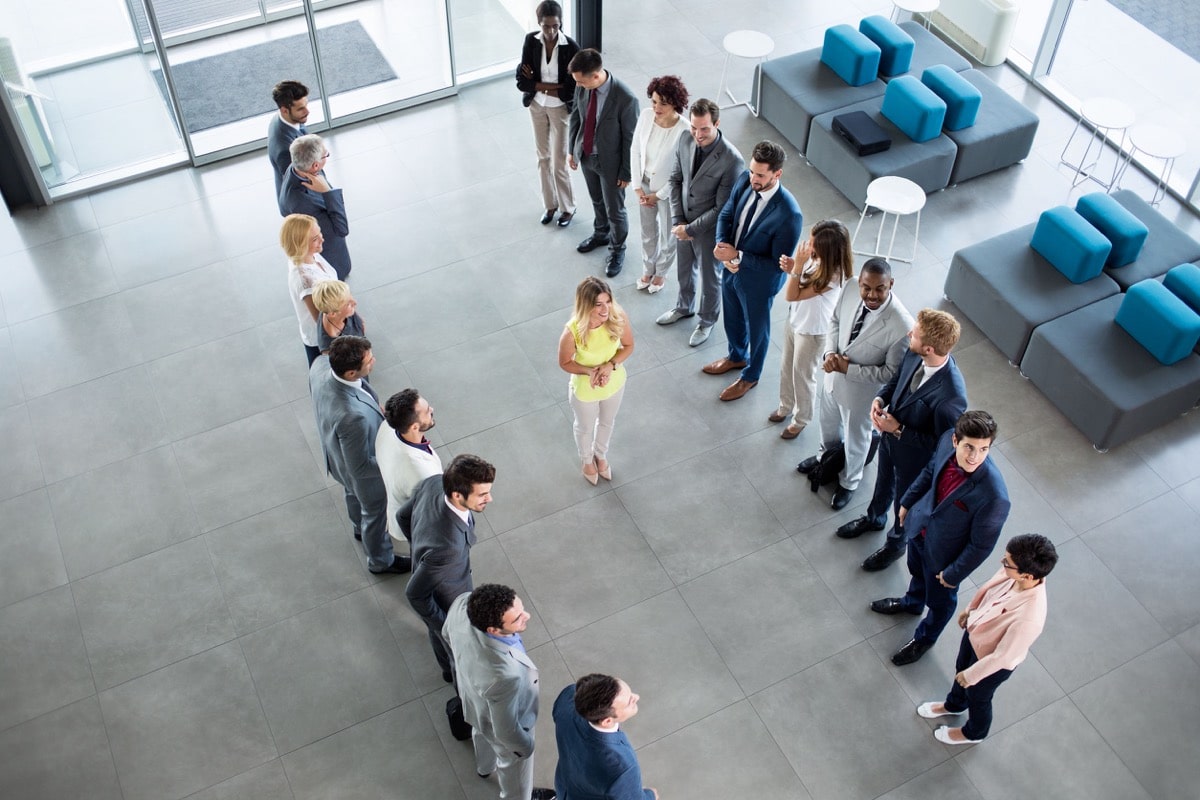 smiling young leader standing in front of his partners who applauding; concept: HR leaders