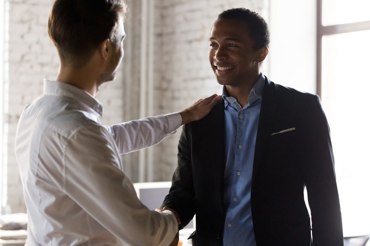 two businessmen shake hands; ai-powered software and hiring concept