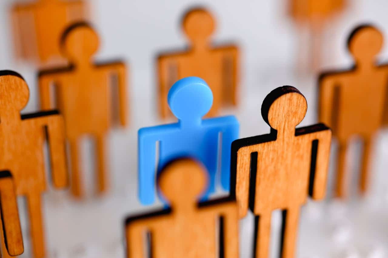 small toy men, one stands out; succession plan concept