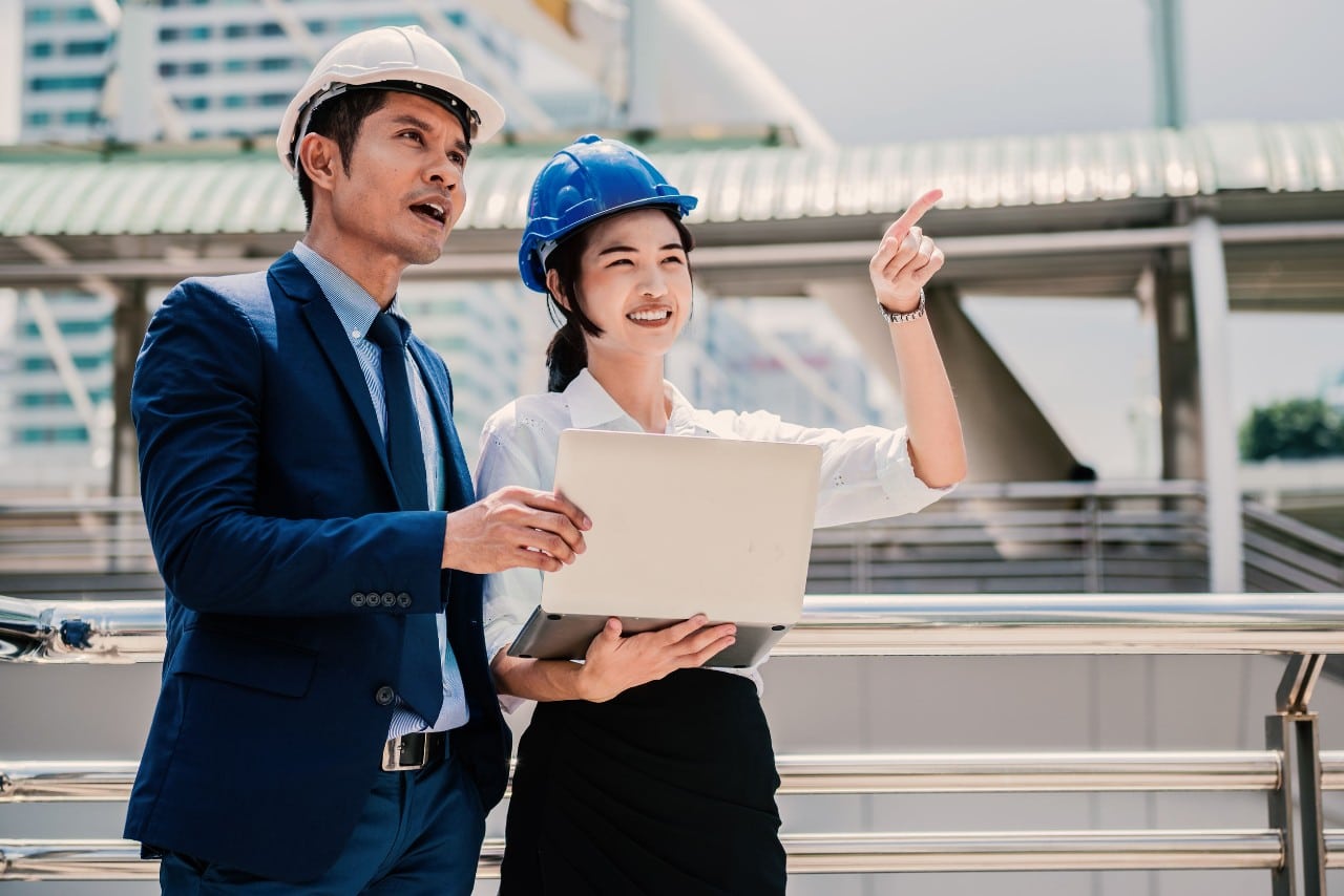 two professionals in hard hats discuss the job site; managers should encourage internal mobility concept