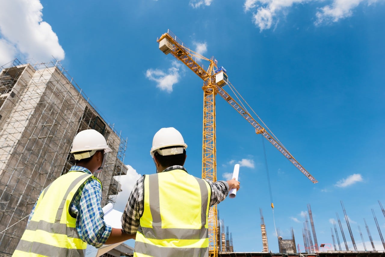 two construction workers discuss on a job site; hiring for adjacent skills concept