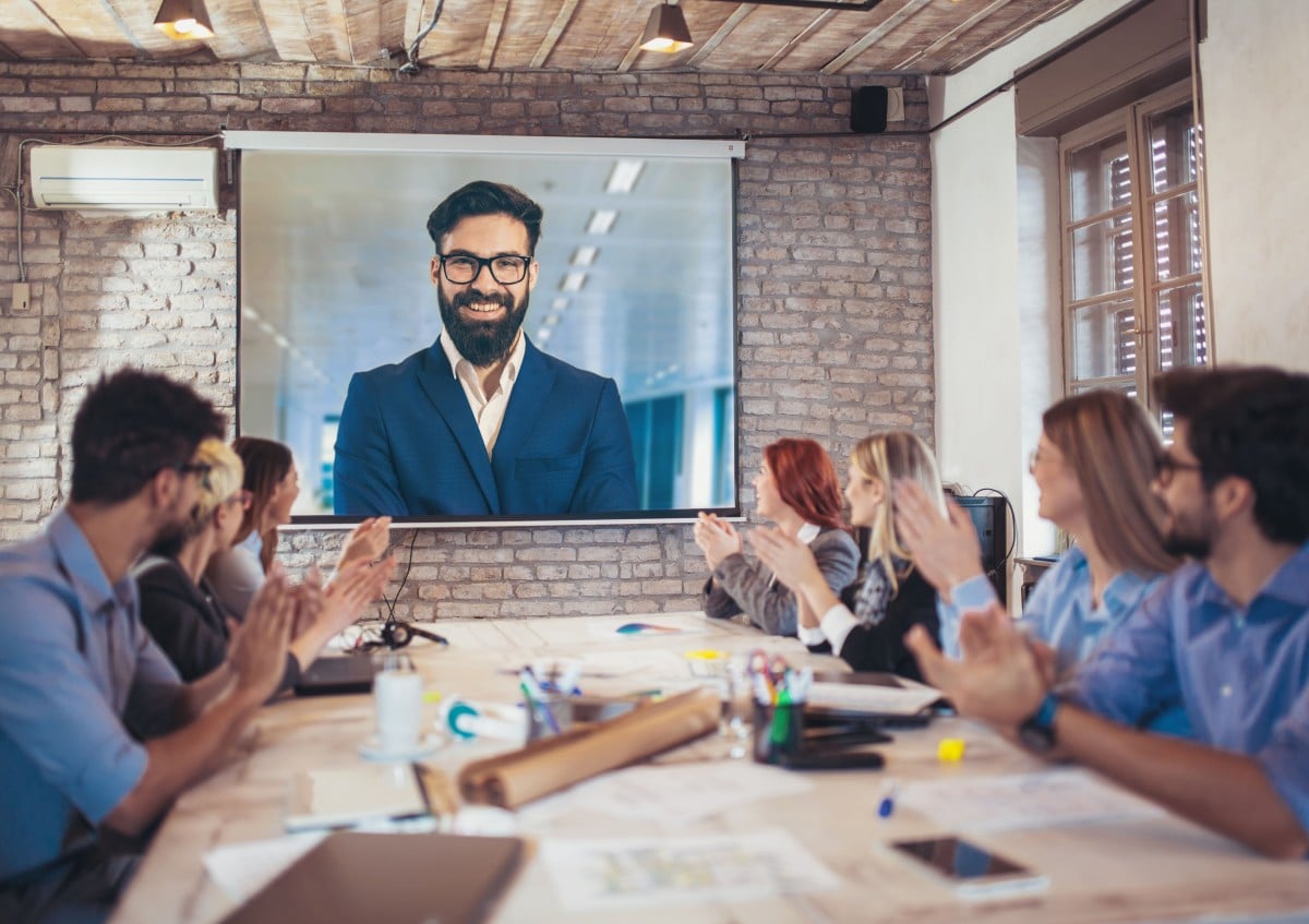 officer workers in a conference room watching an online presentation; concept: remote onboarding