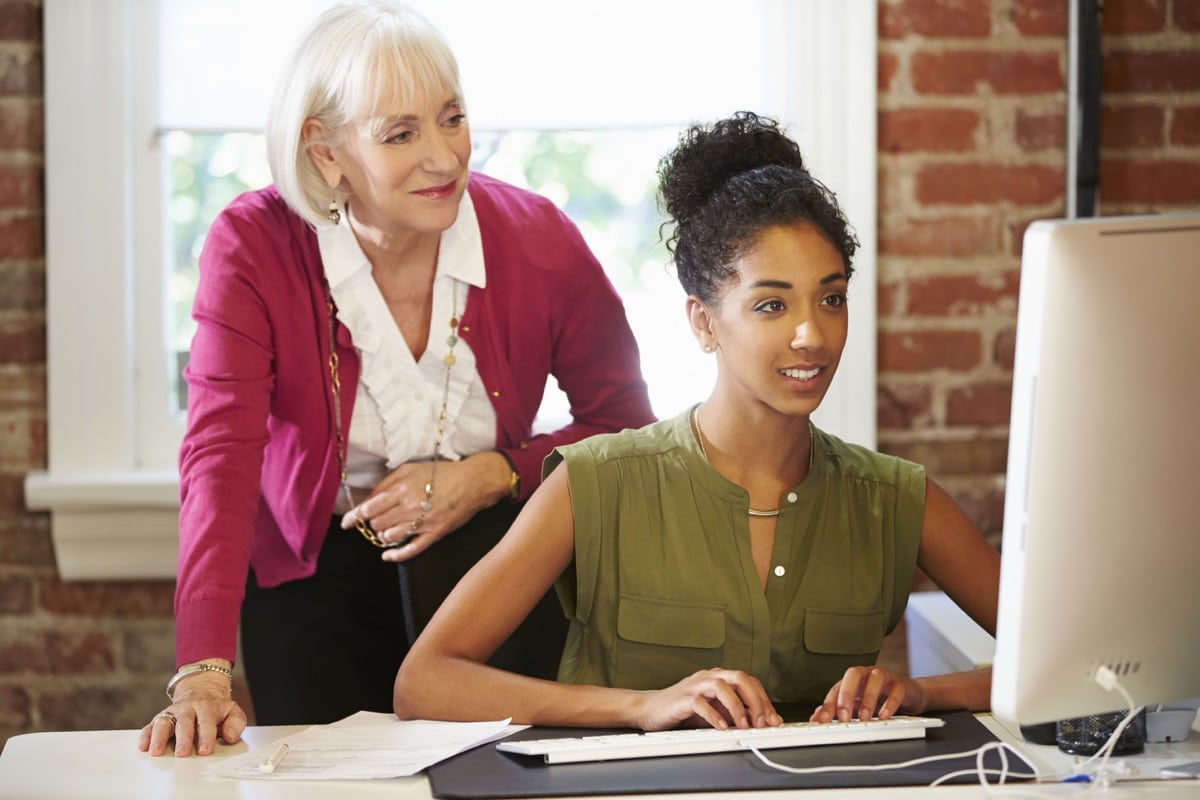 Two Women Working At Computer In Contemporary Office; talent management after hiring concept