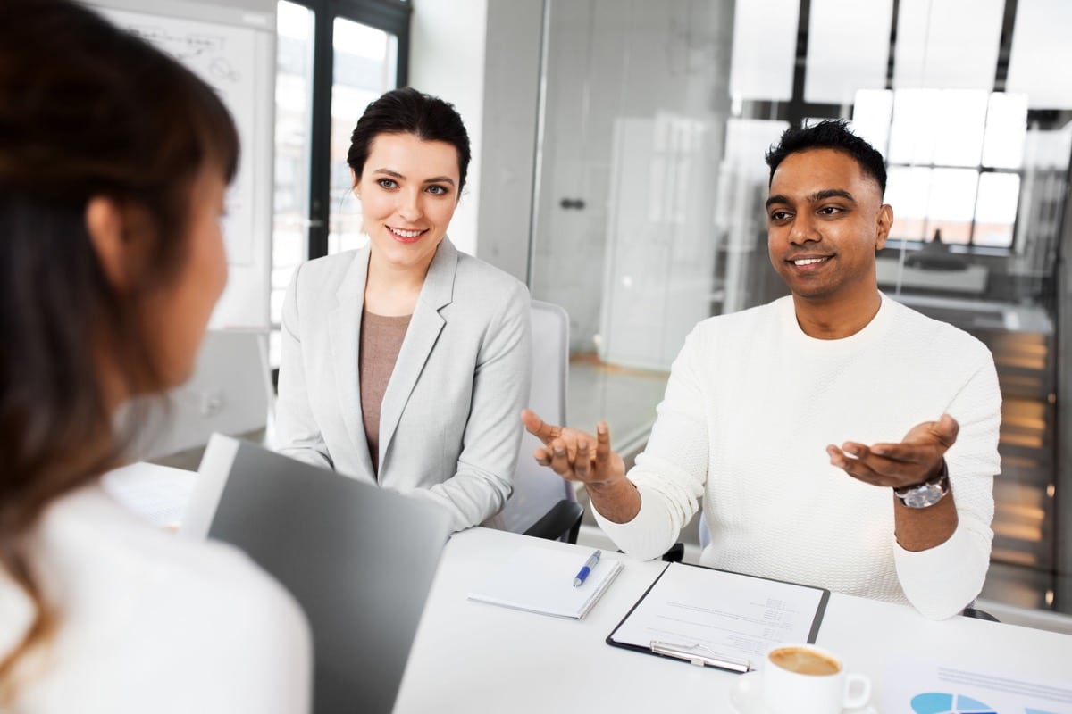 new job, hiring and employment concept - international team of recruiters having interview with female employee at office
