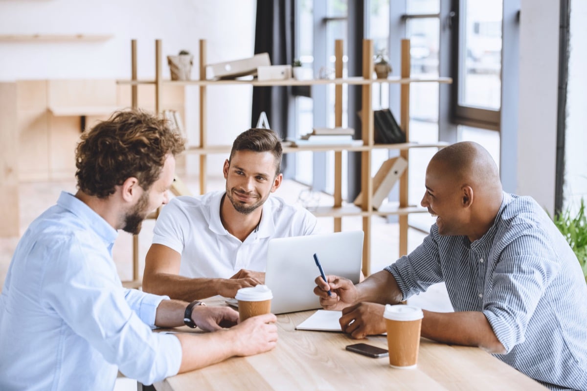 multicultural business people working on laptop at meeting in office; job-hopping job market concept