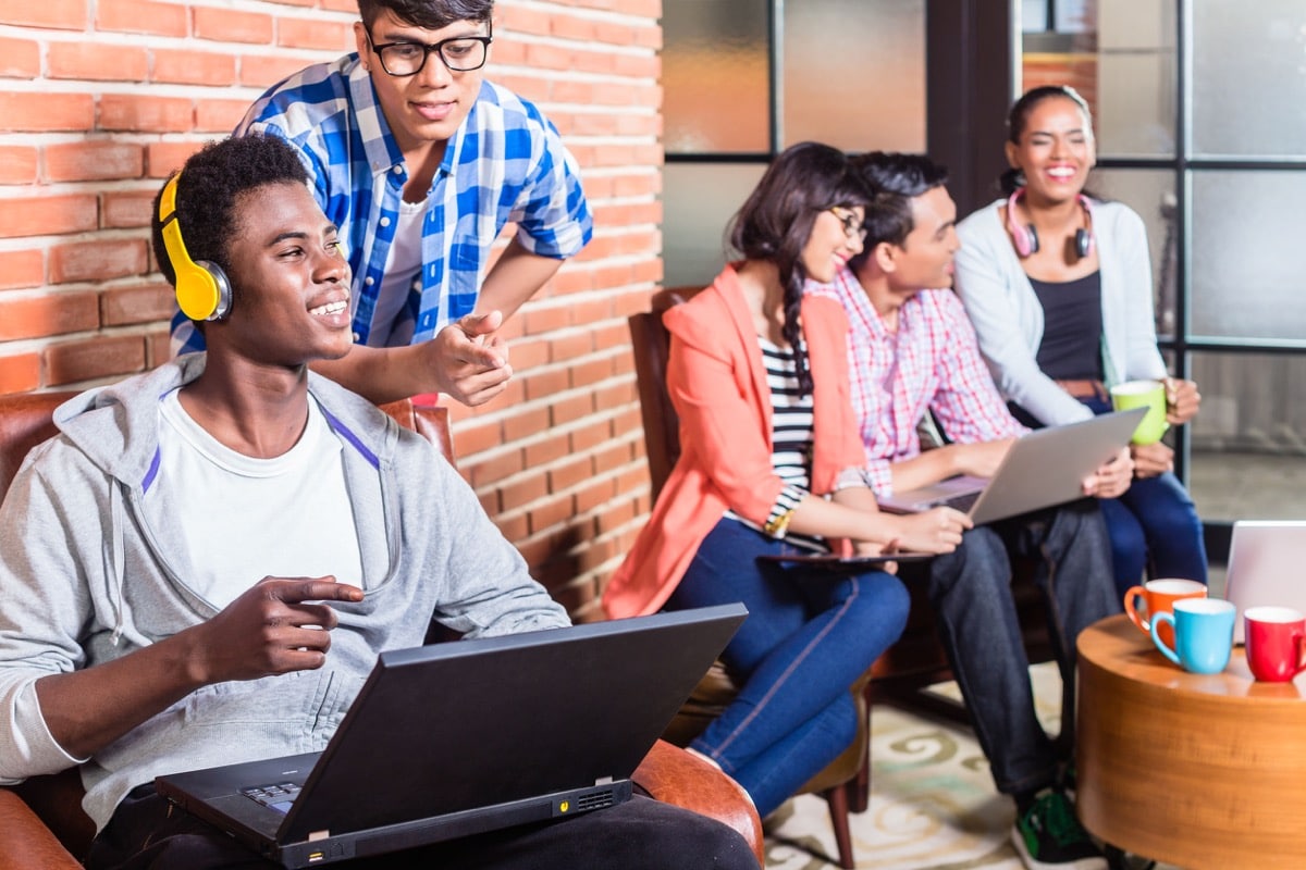 Computer programmer in start-up company coding, co-worker is looking over his shoulder; recruiting tech talent concept