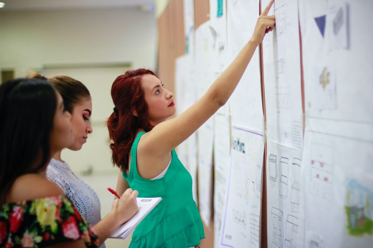 three coworkers share ideas on a whiteboard; artificial intelligence, automated talent management concept
