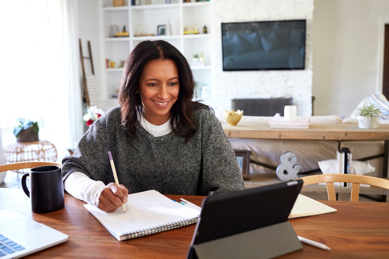 freelance worker at kitchen table; concept: remote onboarding